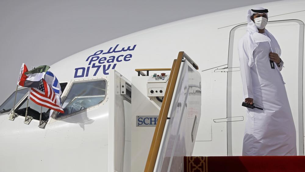An official stands at the door of an Israeli El Al airliner after it landed in Abu Dhabi, United Arab Emirates, on Monday. The headrests and food trays had the words 
