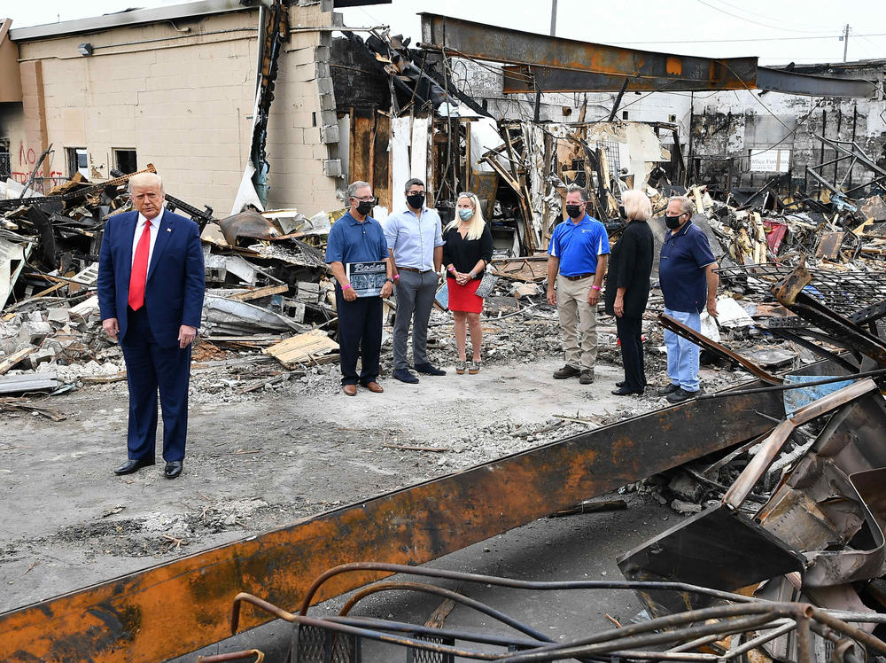 President Trump tours an area affected by civil unrest in Kenosha, Wis., on Tuesday. While there, he attacked Democratic leaders in other nearby big cities, saying they aren't doing enough on crime.