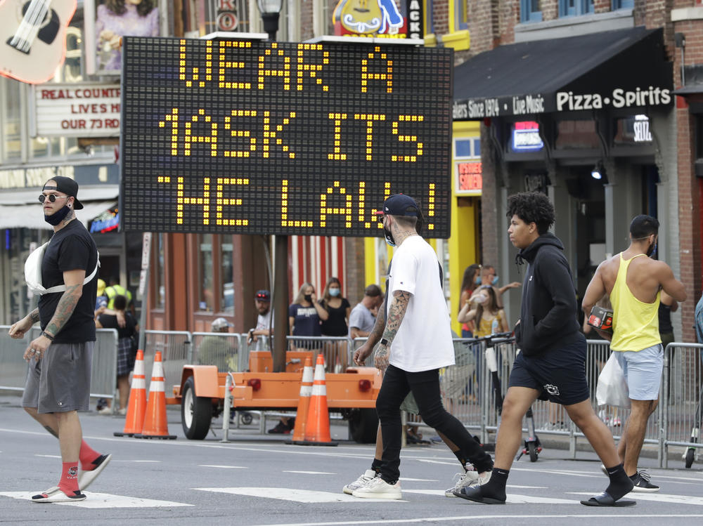 A sign reminds tourists to wear masks while visiting honkey-tonks and restaurants in downtown Nashville on Aug. 5.