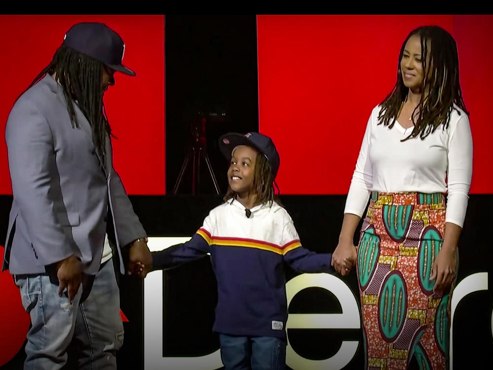 Shaka Senghor (left), Ebony Roberts (right), and their son Sekou speak on the TED stage.