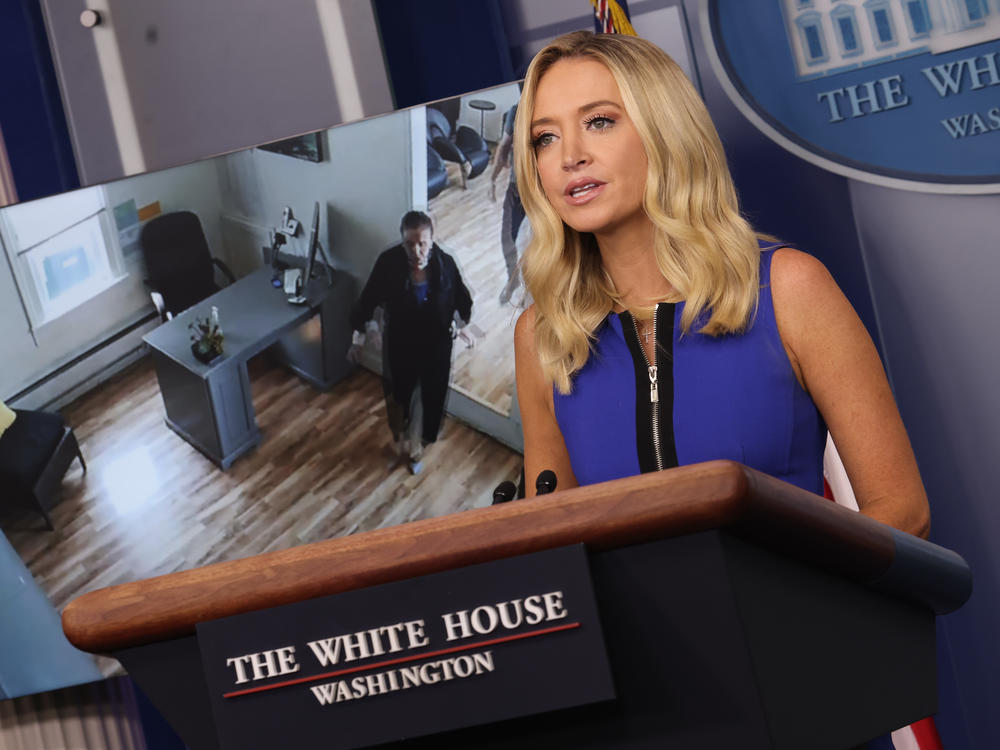 White House press secretary Kayleigh McEnany holds a briefing Thursday as a video of House Speaker Nancy Pelosi entering a San Francisco hair salon plays in the background.