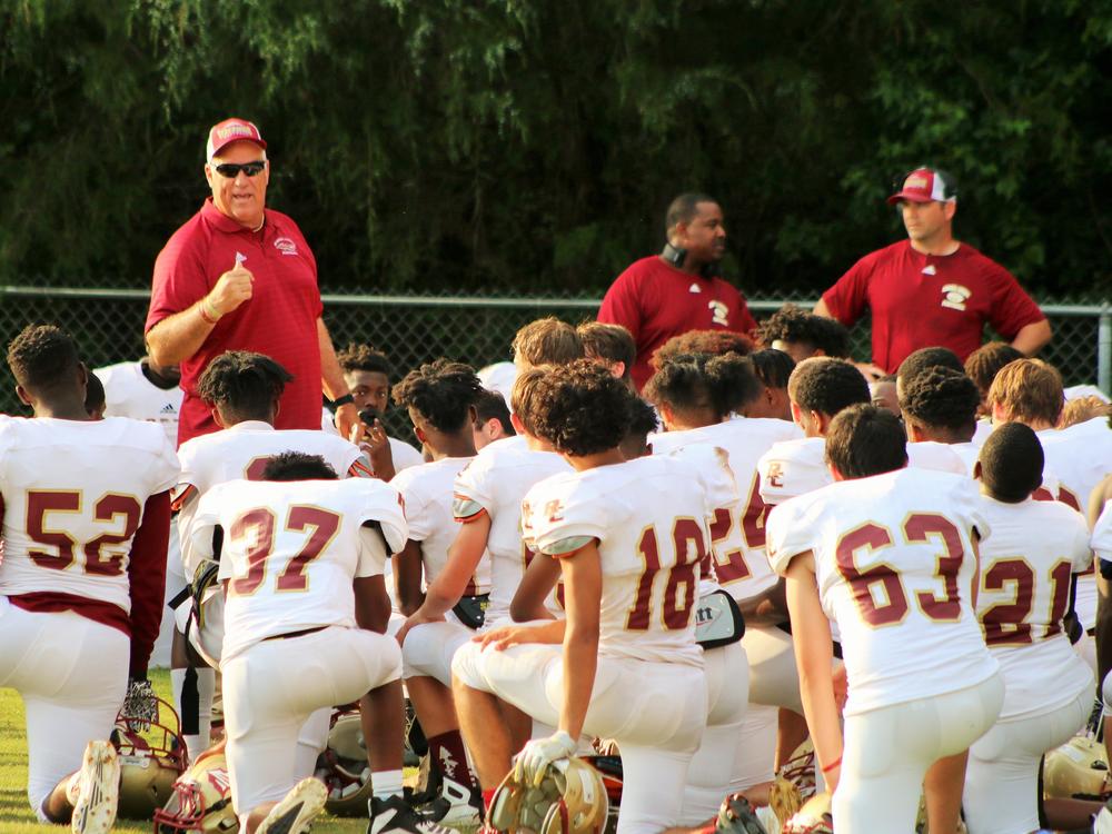Russell County High School football coach Mark Rose speaks to players during a spring game in 2019. He's against having his team play this season without state-mandated coronavirus testing. Alabama high school officials, like in many other states, say there's not enough money for tests.