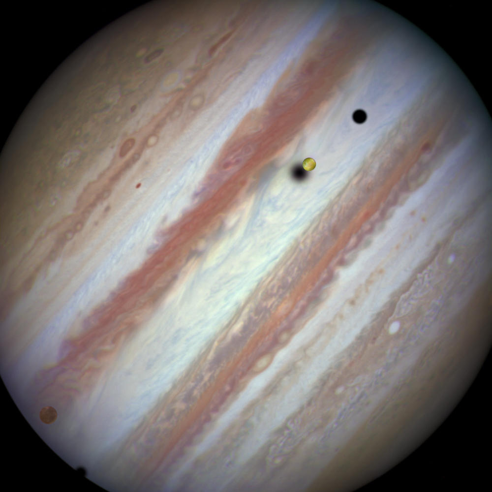 An image captured by the Hubble Space Telescope as three of Jupiter's largest moons parade in front of the gas giant on Feb. 5, 2015. On the left is the moon Callisto and on the right, Io. The shadows from Europa, which cannot be seen in the image, Callisto and Io are strung out from left to right.