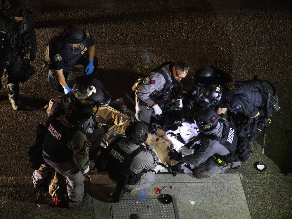 Emergency personnel treat Aaron Danielson in Portland, Ore., Aug. 29. The man suspected of killing Danielson, Michael Reinoehl, was killed by law enforcement agents as they attempted to arrest him Thursday night.