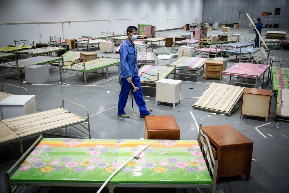 A worker walks past bed frames as workers demolish installations at Wuhan's first makeshift hospital built to treat patients infected with COVID-19 in China's central Hubei province in August.