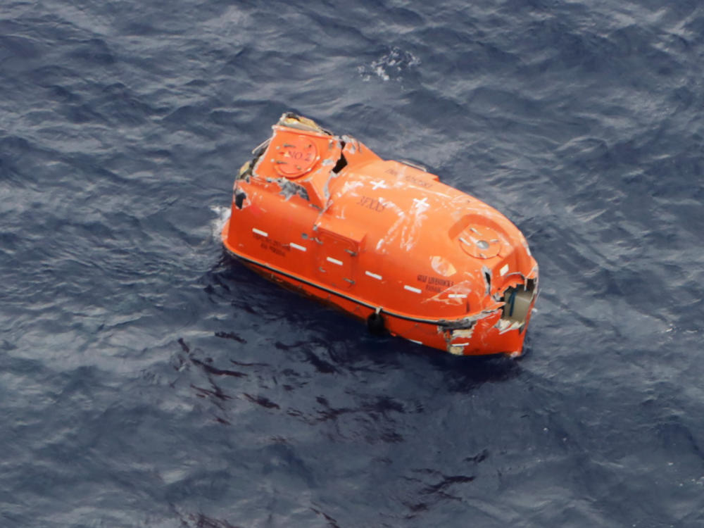 An unoccupied lifeboat drifts near Kodakarajima island. Japanese authorities are racing to find dozens of missing sailors from a cargo ship that sank in a typhoon.