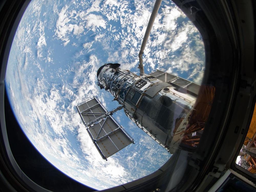 An STS-125 crew member onboard the space shuttle Atlantis snaps a still photo of the Hubble Space Telescope following grapple of the giant observatory by the shuttle.