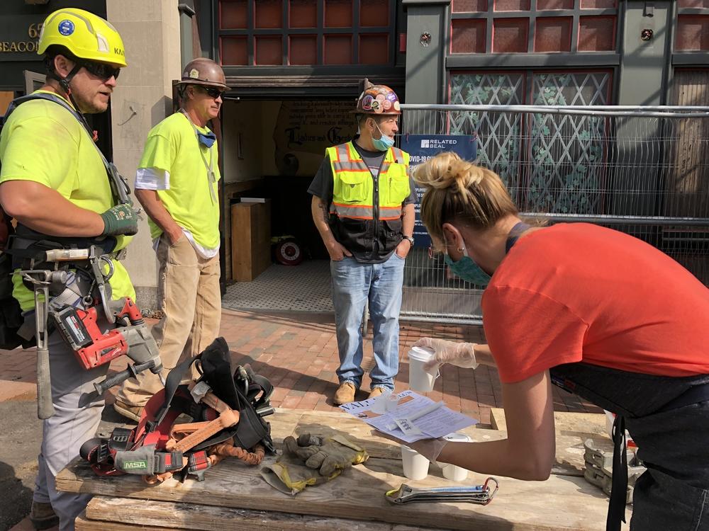 Lauren Moran, who's been helping her extended family as they reopen Cornwall's, brings menus and free coffees over to a construction crew working next door, hoping to stir up business, at a time when customers are scarce.