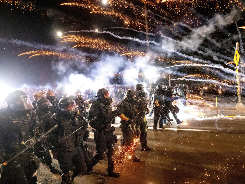 Police in riot gear unleashed a volley of tear gas and flash-bang grenades on the protesters after police say some lobbed 