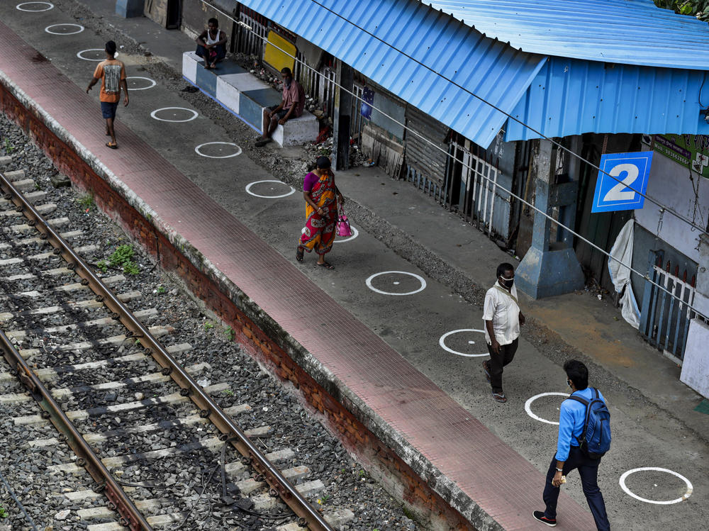 People walk through a railway station platform marked with circles to maintain physical distance in Kolkata, India, Monday. India's increasing coronavirus caseload made it the pandemic's second-worst-hit country behind the United States.