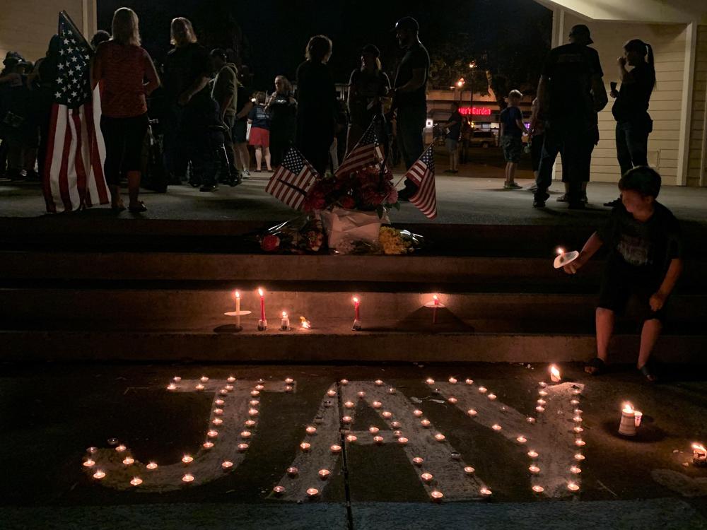 A boy lights a candle commemorating Aaron 'Jay' Danielson on Saturday night. Danielson, 39, was a member of Patriot Prayer. He was killed during a Portland protest on Aug. 29.