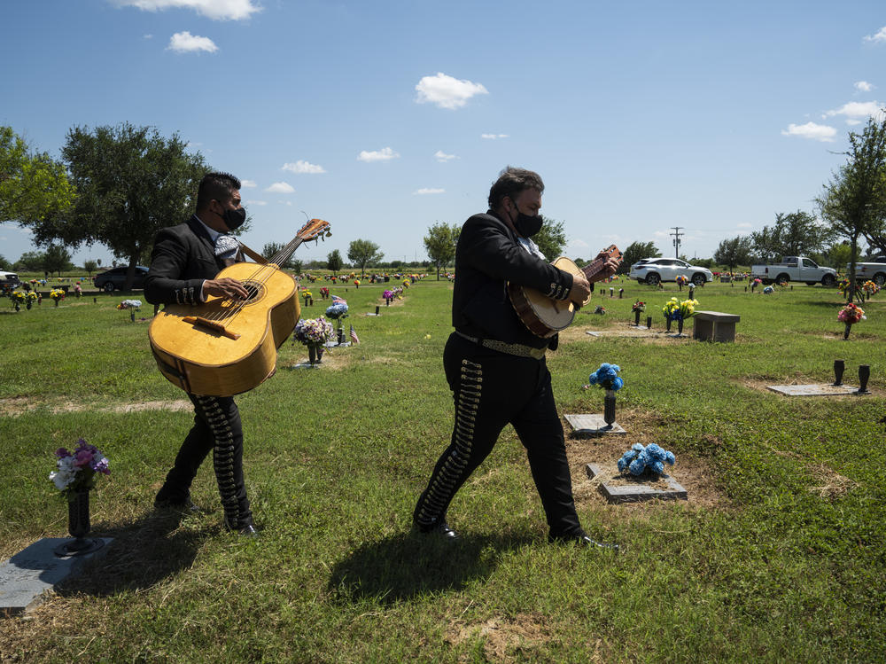 Hector Guerra, right and Juan Carlos Sanchez, from El Mariachi Continental, make their way to a funeral service in Donna, Texas on Aug. 21.