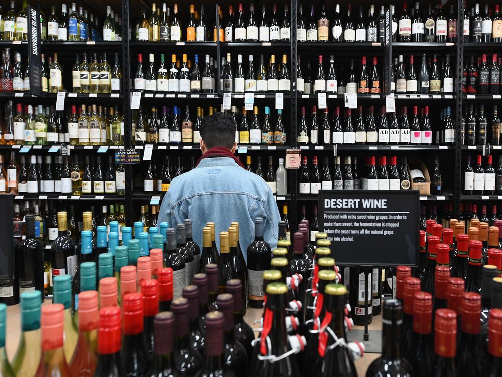 A patron stands in front of a shelf full of wine bottles at a liquor story in the Brooklyn borough of New York City on March 20.