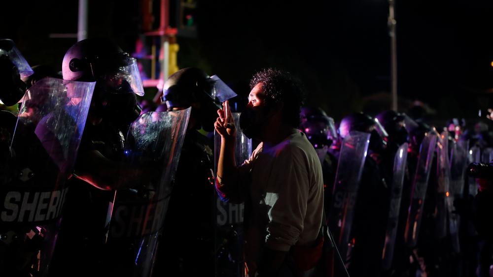 A protester stands face to face with police during demonstrations over the shooting of Jacob Blake in Kenosha, Wis., in August.