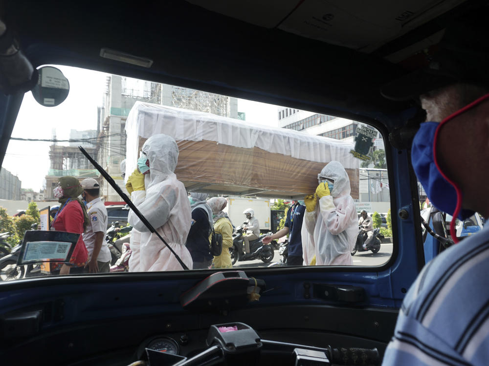 Officials from the Cilandak Subdistrict Office and Police Department carry a coffin in the streets of Jakarta, Indonesia, as part of a campaign to scare people into following pandemic guidelines.