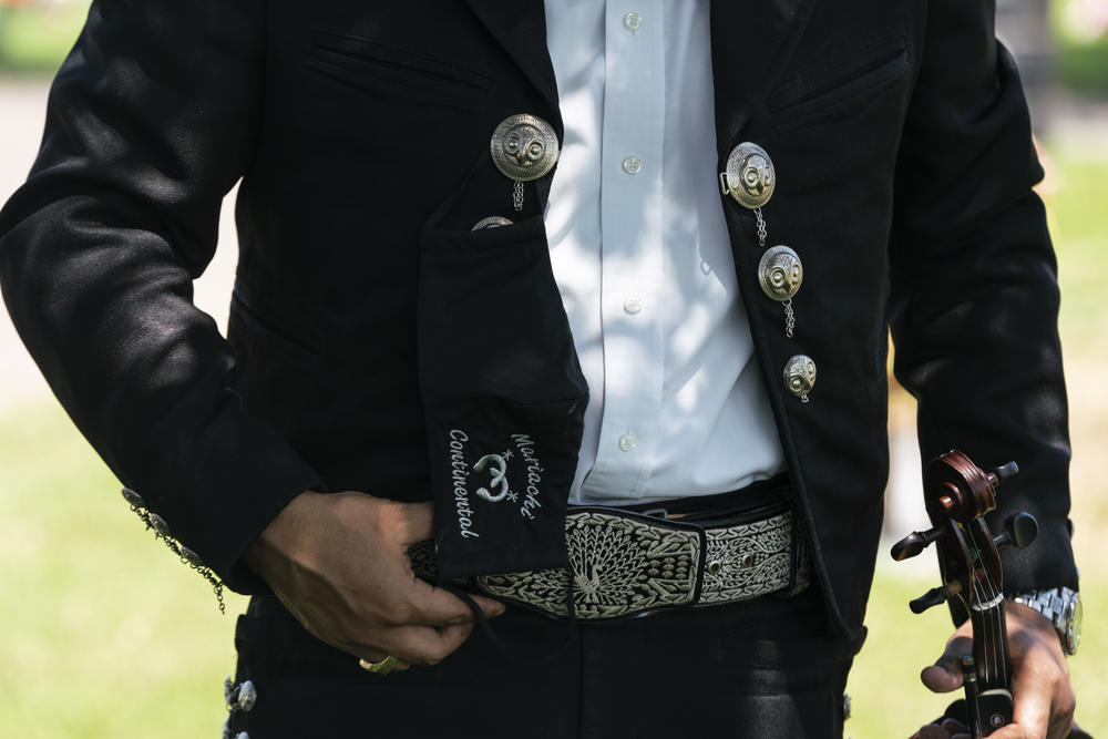 Miguel Lupercio violinist in El Mariachi Continental, waits for the funeral attendees to arrive at the cemetery where he will be playing in Donna, Texas.