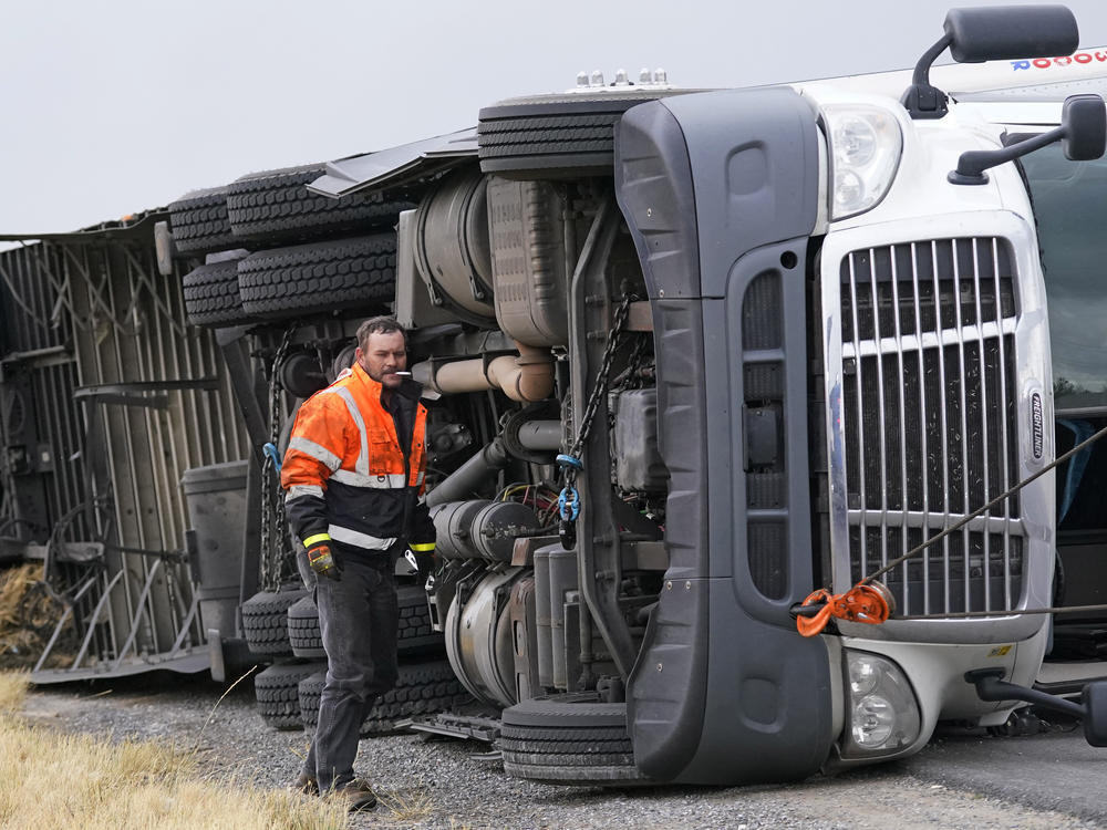 A semi rests in its side after after high winds toppled it on Interstate 15 near Bountiful, Utah, Tuesday.