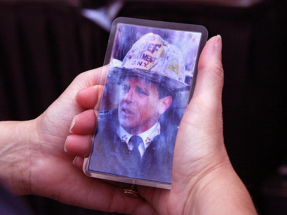 Priscilla Wass of Watertown, Mass., holds a picture of her high school classmate, FDNY Chief of Department Peter J. Ganci Jr., at a gathering outside Boston's Faneuil Hall during a memorial on Sept. 11, 2002.