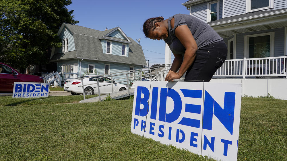 A resident of Kenosha, Wis., puts up a yard sign for Democratic presidential nominee Joe Biden on Sept. 3.