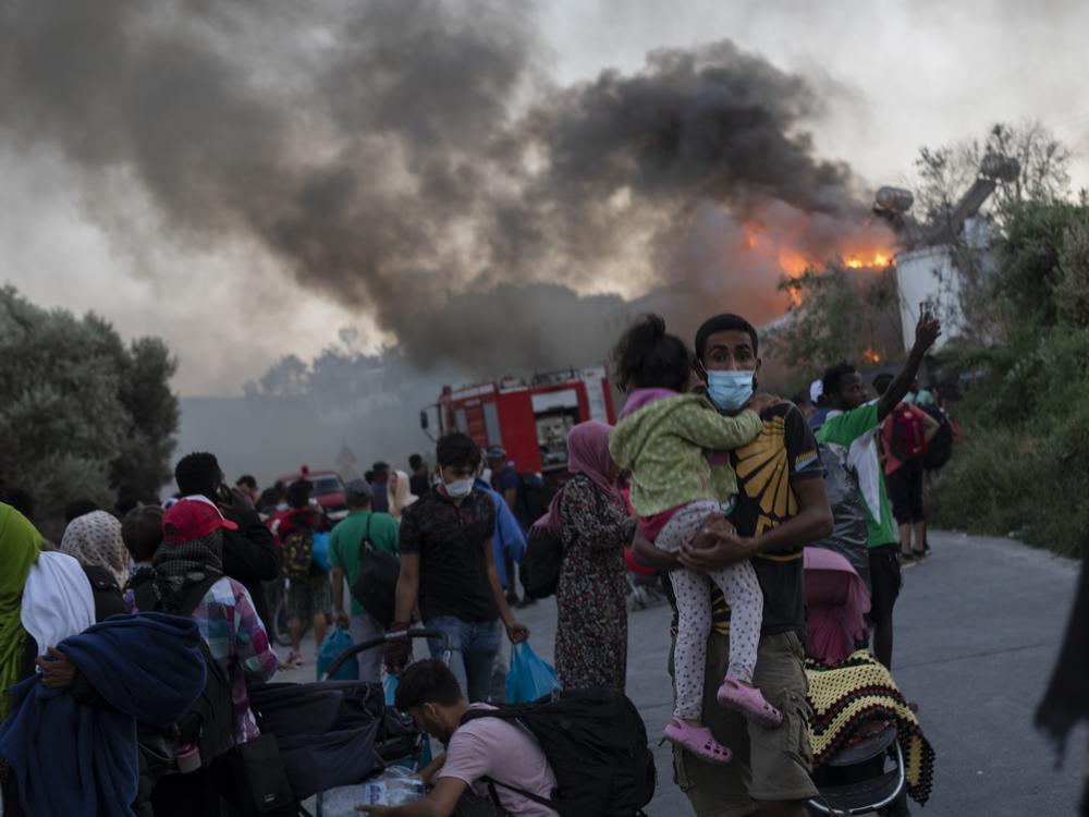 Migrants flee from the Moria refugee camp during a fire on Wednesday. It was one of multiple fires this week in Greece's notoriously overcrowded refugee camp on the island of Lesbos. The fires caused no injuries, but they renewed criticism of Europe's migration policy.