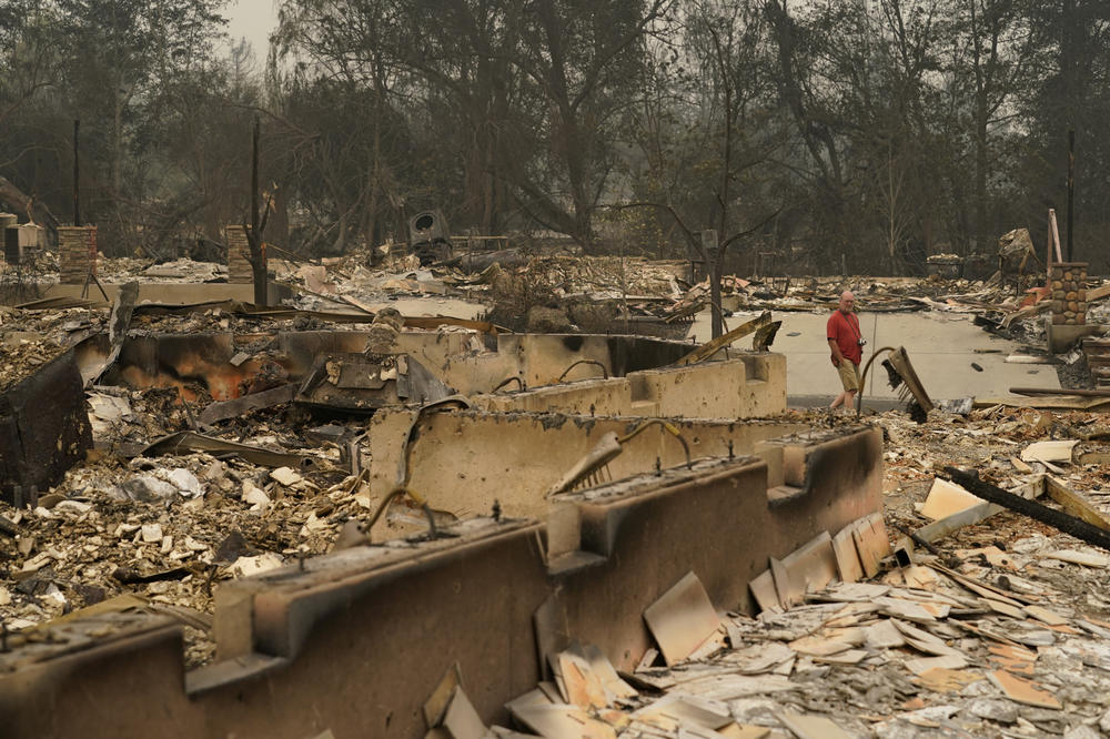 A man walks through a neighborhood destroyed by the Almeda Fire on Friday in Talent, Ore.