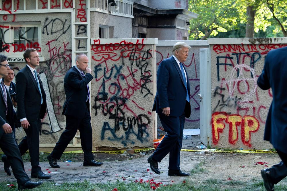 After the police's use of tear gas to clear the area, President Trump emerges from the White House and gets escorted through Lafayette Square to St. John's Episcopal Church for a photo on June 1.