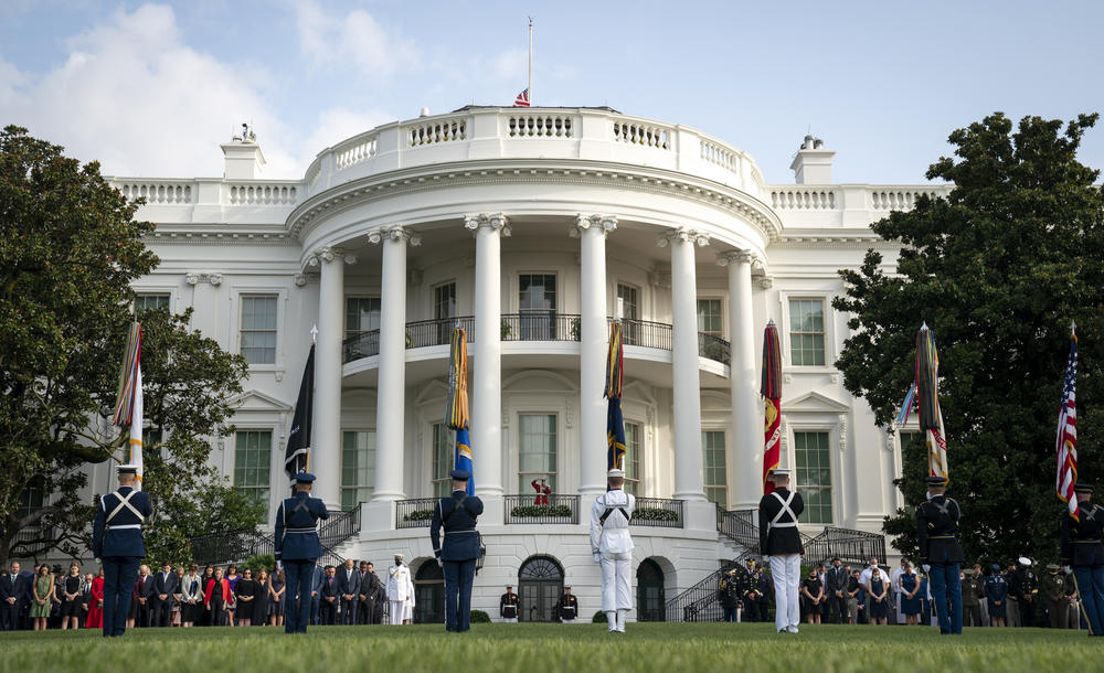 A military honor guard stands on the South Lawn of the White House on Friday as staff members hold a moment of silence in honor of those killed in the Sept. 11 attacks.