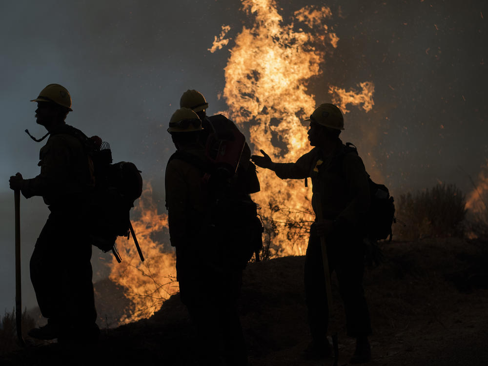 Firefighters monitor a controlled burn along Nacimiento-Fergusson Road to help contain the Dolan Fire near Big Sur, Calif., on Friday.