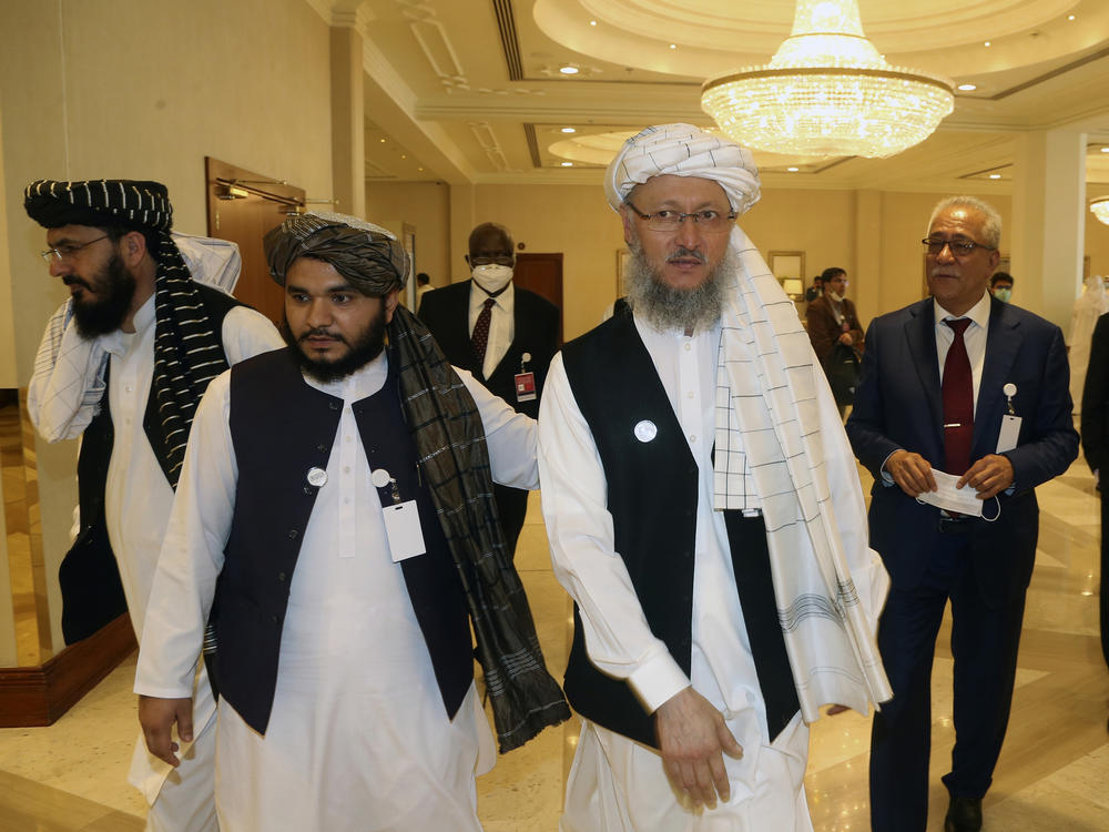 Abdul Salam Hanafi (right), a member of the Taliban negotiating team, heads to the opening session of peace talks between the Afghan government and the Taliban in Doha, Qatar, on Saturday.