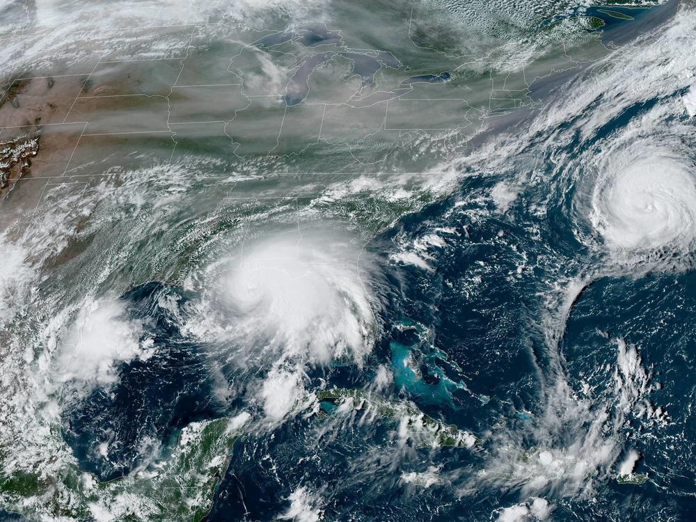 Sally is edging closer to the U.S. Gulf Coast, while Hurricane Paulette moves away from Bermuda out in the Atlantic Ocean. This satellite view also shows smoke from massive wildfires in the U.S. West.