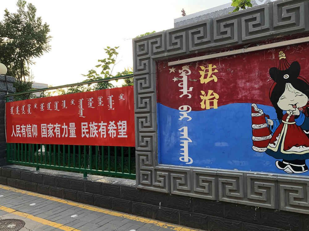 A sign (left) outside a Mongolian-language school in Hohhot, Inner Mongolia, reads: 
