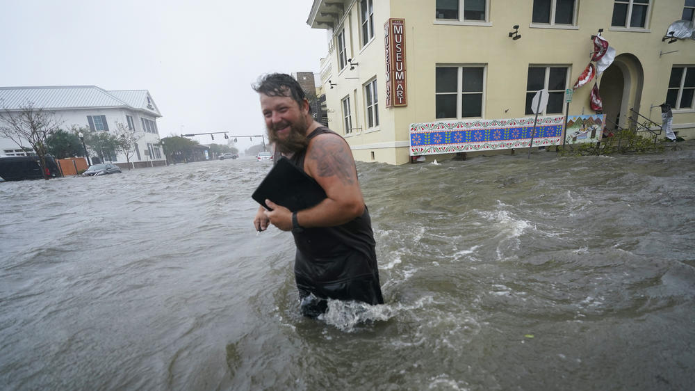 Trent Airhart wades through floodwaters after retrieving items from his vehicle in downtown Pensacola, Fla., Wednesday. Hurricane Sally is causing flooding across a wide area of the northern Gulf Coast.