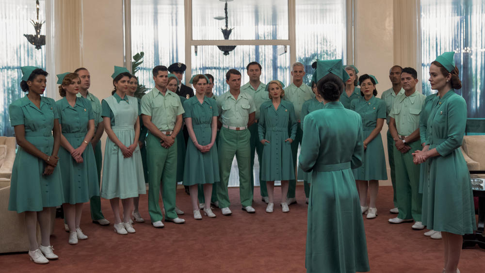 The staff assembles in front of Nurse Bucket (Judy Davis) in <em>Ratched</em>.