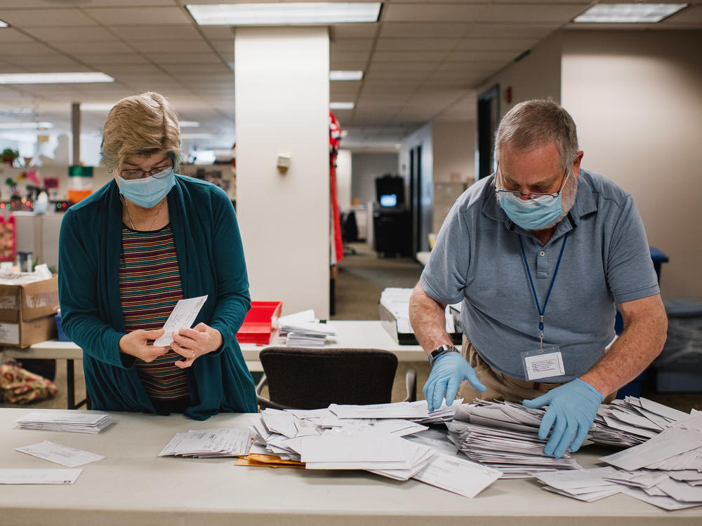 Andrea Lerner (left), and her husband, Ira Lerner, sift through the mail-in applications at the Voter Registration office in the Lehigh County Government Center in Allentown, Pa.