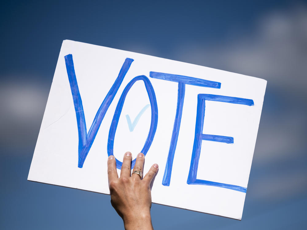 A man holds a sign that says 