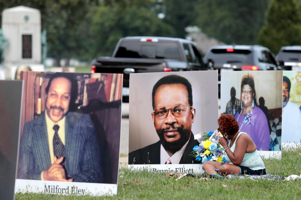 Images of Detroit-area residents who died from COVID-19 line a street during a drive-through memorial on Sept. 1 on Belle Isle in Detroit. The number of U.S. dead has crossed the 200,000 mark — and the figure could nearly double by the end of the year, experts say.