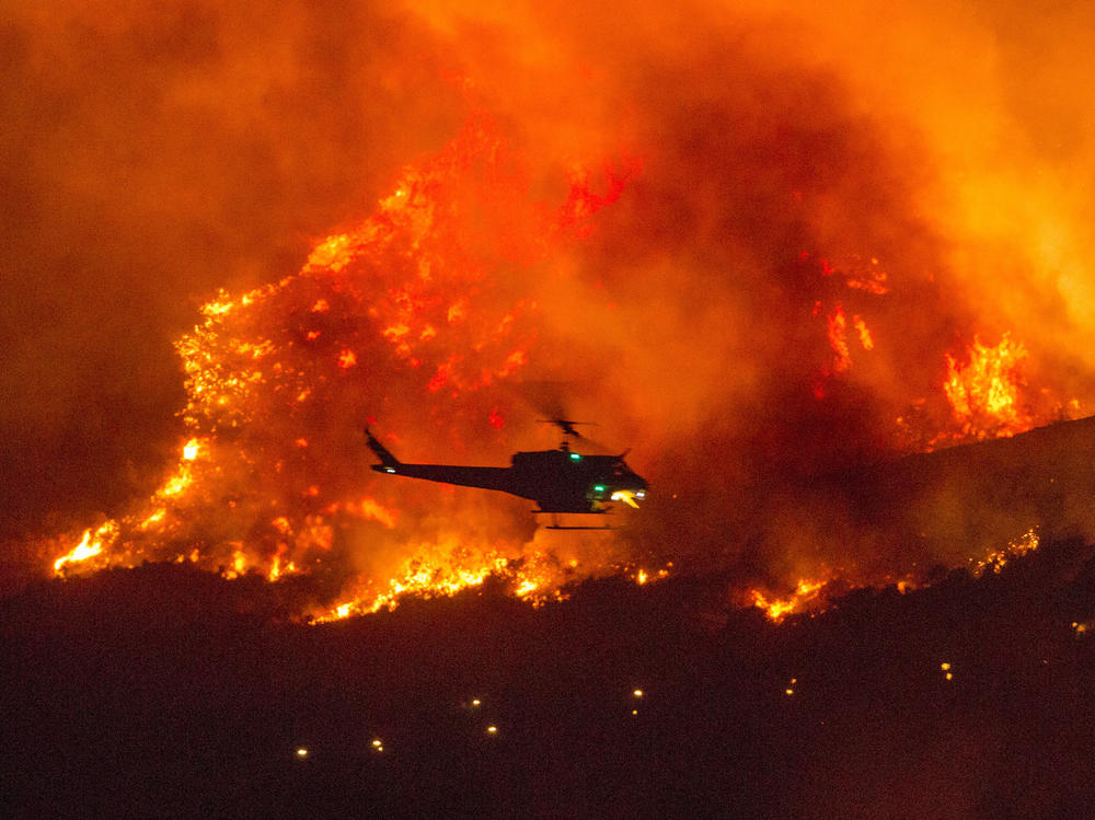 A helicopter prepares to drop water at a wildfire in Yucaipa, Calif., on Sept. 5. A firefighter was killed in the El Dorado blaze on Thursday.