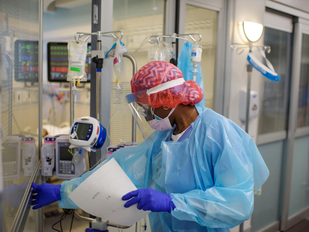 Niticia Mpanga, a registered respiratory therapist, checks on an ICU patient at Oakbend Medical Center in Richmond, Texas. The mortality rates from COVID-19 in ICUs have been decreasing worldwide, doctors say, at least partly because of recent advances in treatment.