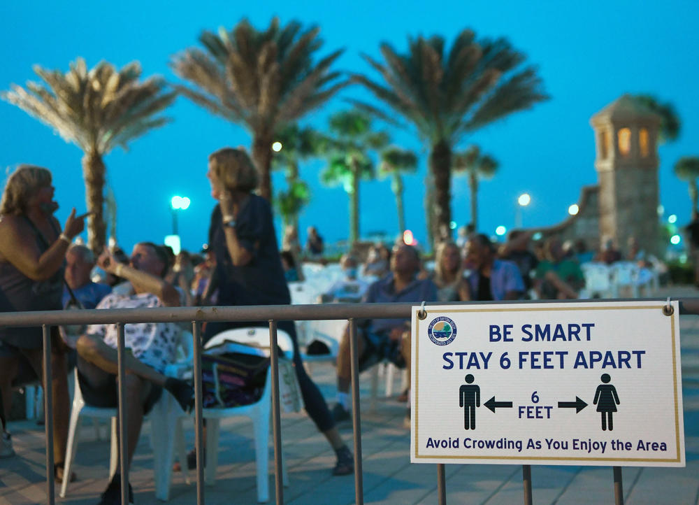 People attend a free concert at the Daytona Beach Bandshell on Labor Day weekend in Daytona Beach, Fla. For months, public health officials around the country have asked people to practice social distancing to slow the spread of the virus.