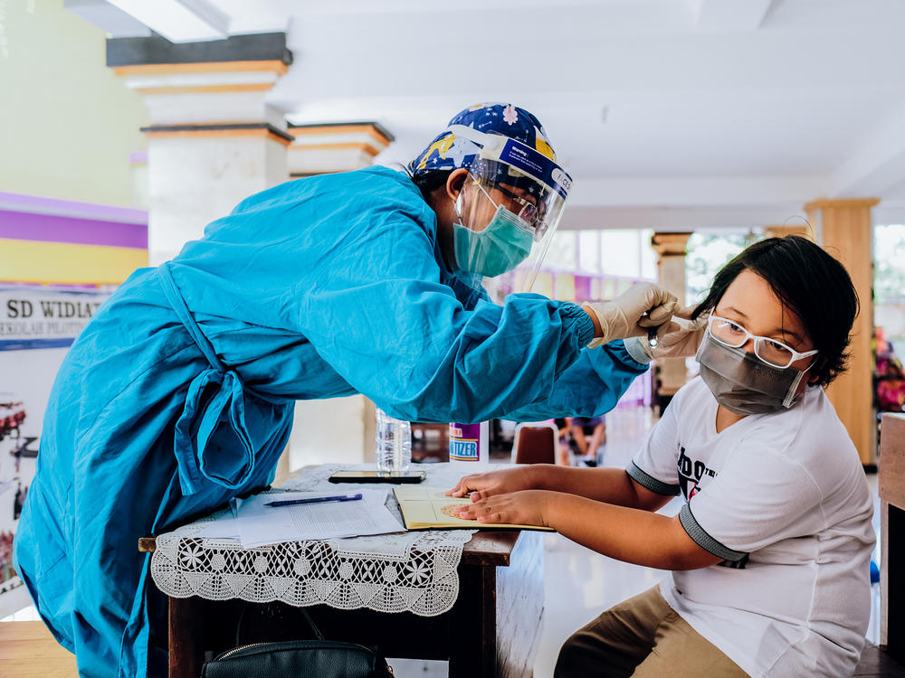 Vaccines for measles-rubella and cervical cancer are administered at a school in Jimbaran, Indonesia. Vaccination rates have dropped during the pandemic.