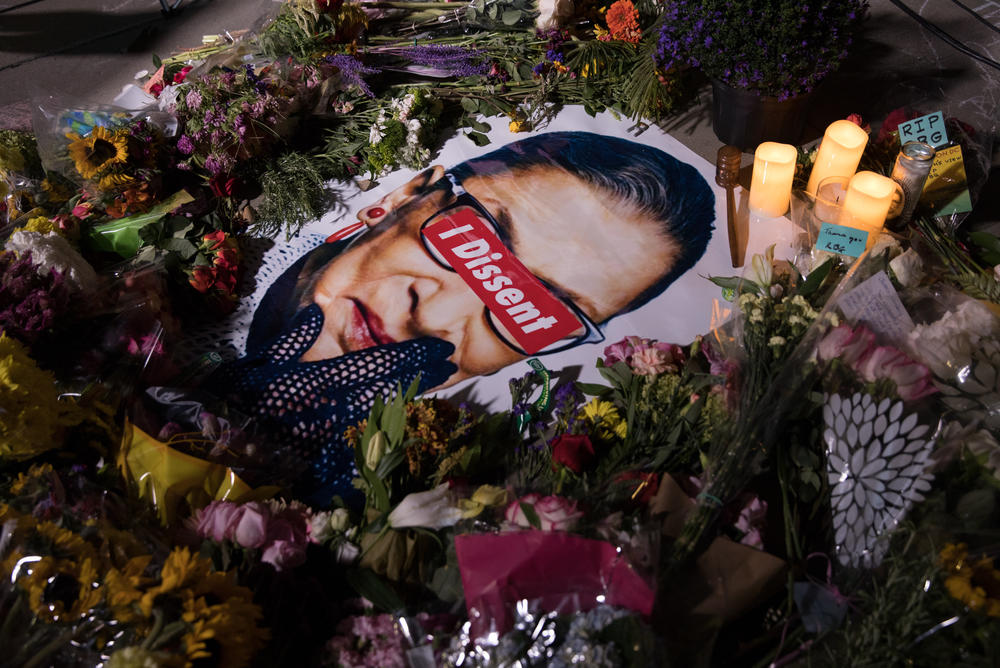 An image of Ruth Bader Ginsburg sits surrounded by flowers during the vigil.