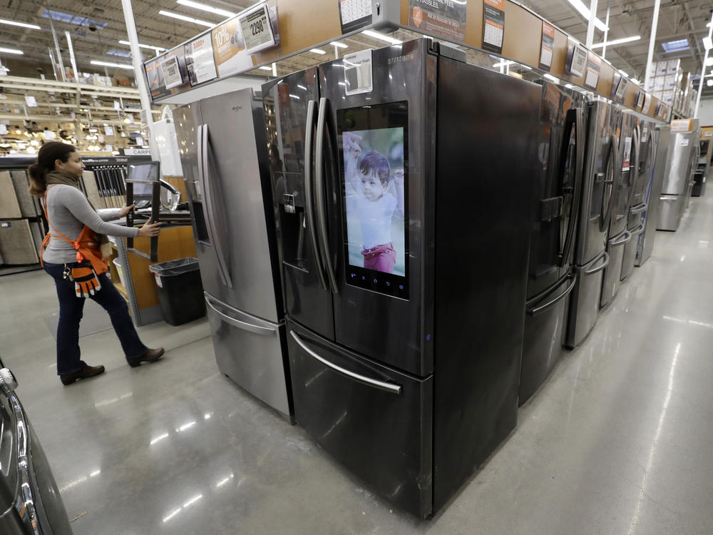A worker pushes a cart past refrigerators at a Home Depot in Boston in January, before the coronavirus pandemic threw a monkey wrench into the supply and demand of major appliances.