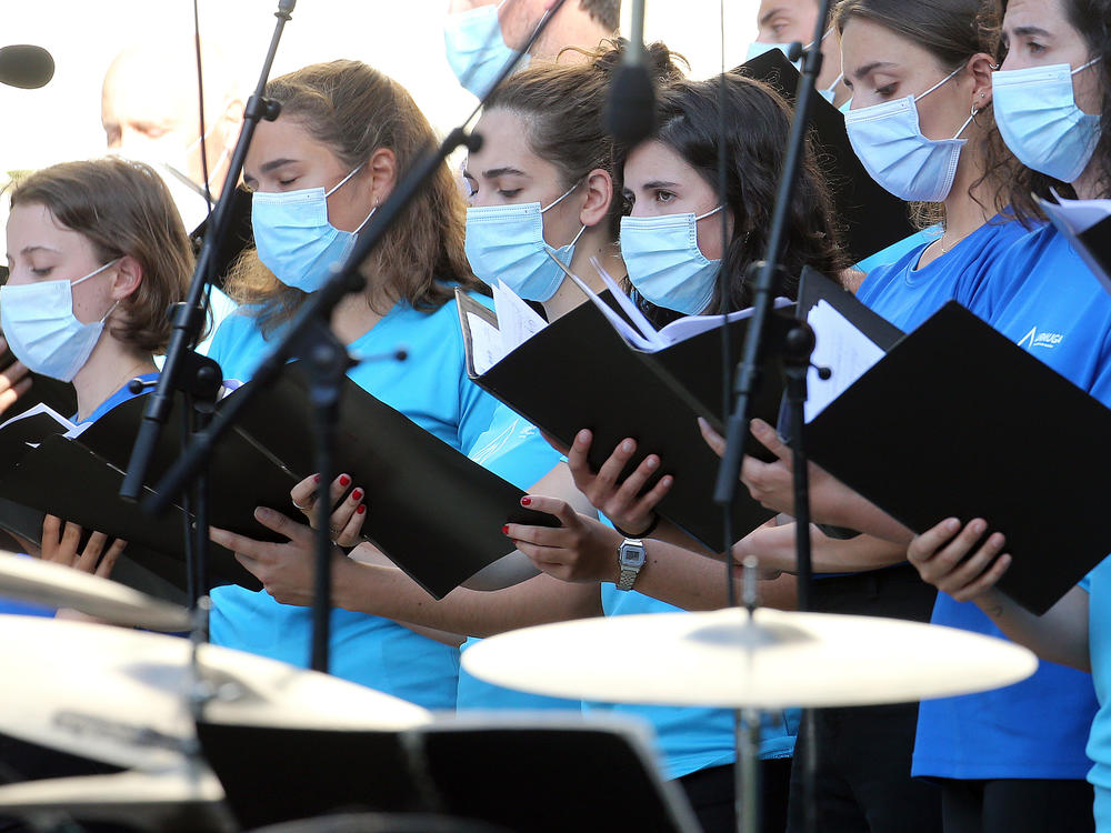 The Centers for Disease Control and Prevention briefly posted new guidance to its website stating that the coronavirus can commonly be transmitted through aerosol particles, which can be produced by activities like singing. Here, choristers wear face masks during a music festival in southwestern France in July.