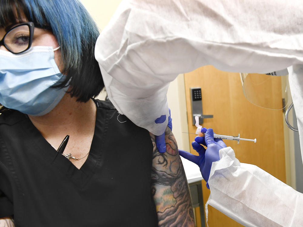 Nurse Kathe Olmstead (right) gives volunteer Melissa Harting an injection in a study of a possible COVID-19 vaccine developed by the National Institutes of Health and Moderna Inc.