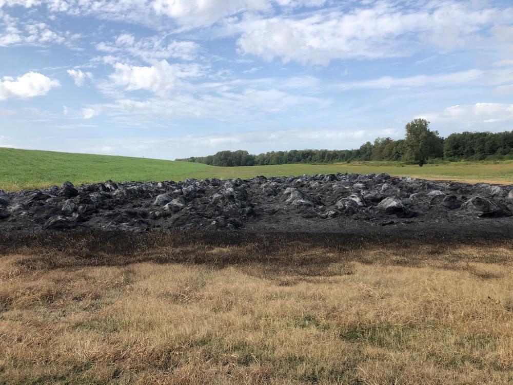 Vandals struck Terry Fuller's farm a few days ago, burning 367 bales of hay. Fuller is trying to limit use of a herbicide called dicamba, which has pitted farmers against each other.