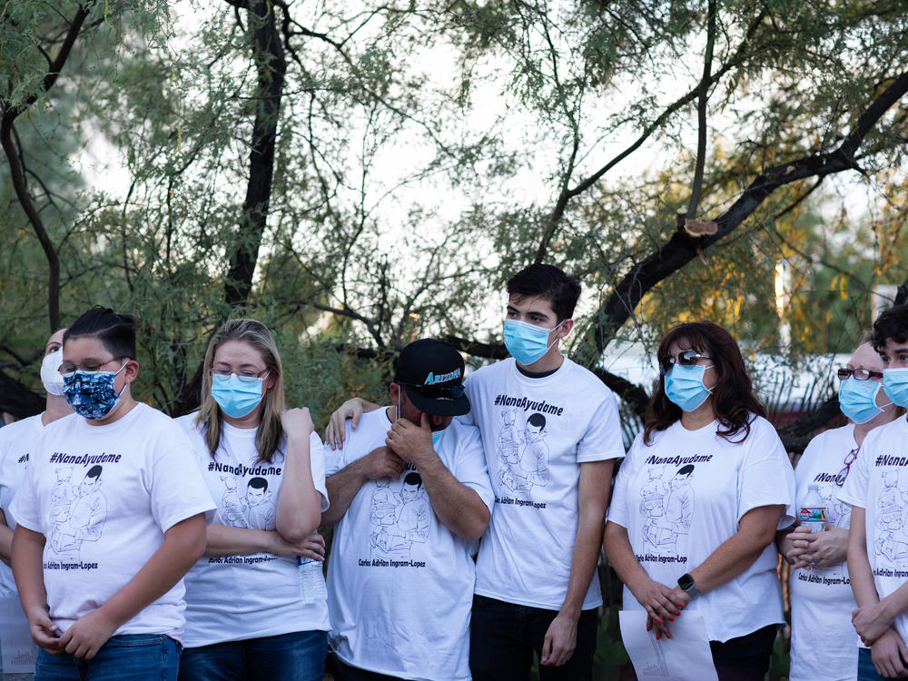 Community members and family wear shirts that read 