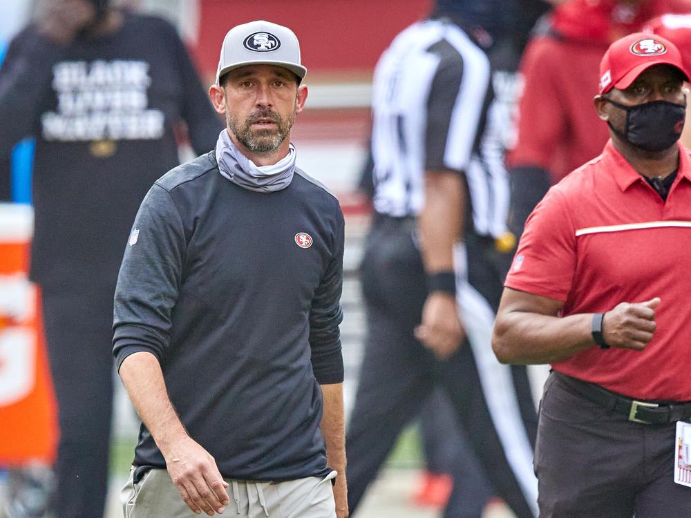 The NFL has fined San Francisco 49ers head coach Kyle Shanahan and two other coaches for not following rules about keeping their faces covered. Here, Shanahan walks off the field after his team's Sept. 13 game against the Arizona Cardinals.