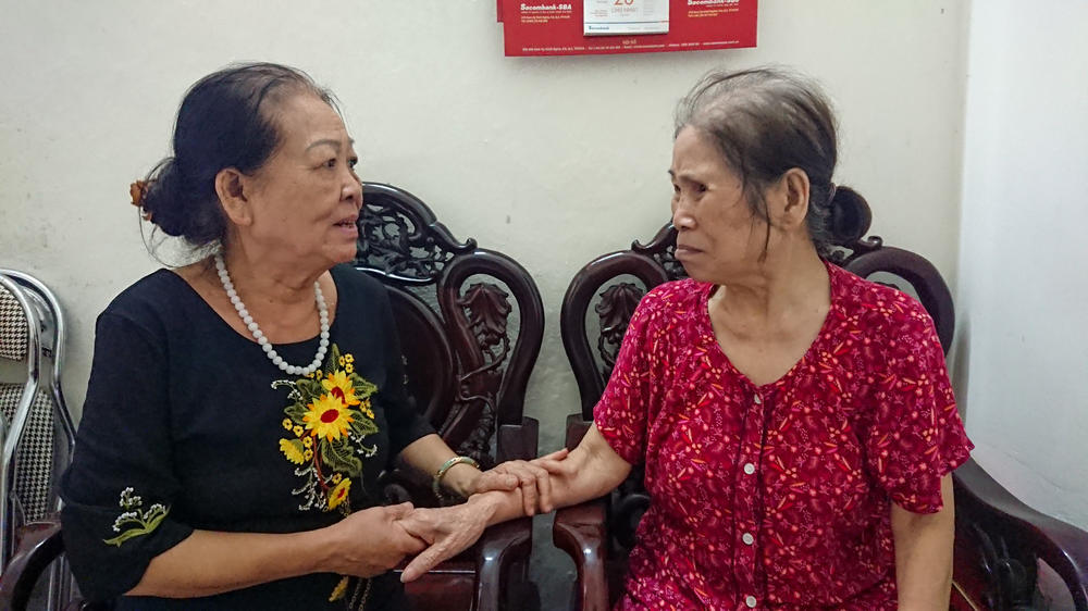 Dao, left, sits with club member Ms. Báu, who is seeking financial assistance from the club. Some funds are available to members in need.