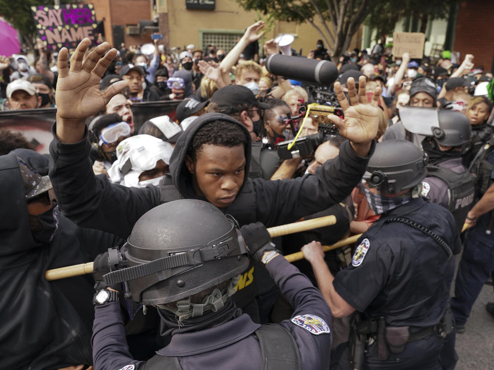 Police and protesters converge during a demonstration, Wednesday in Louisville, Ky. A grand jury has indicted one officer on criminal charges six months after Breonna Taylor was fatally shot by police in Kentucky.