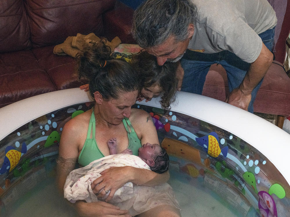 Morgan Cooper holds newborn Lourice as her husband Saleh Totah and 4-year-old son look on. Lourice was delivered in June in a home birth in an inflatable swimming pool in the family's home in the West Bank city of Ramallah. They planned to travel to the U.S. but faced bureaucratic obstacles.